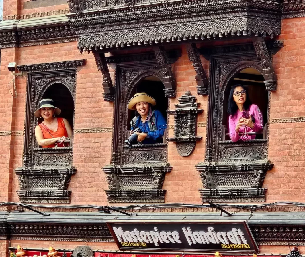 Nepal Photography Tour - Guests Pose in Antique Newari Wooden Window (Ankhi Jhyaal)